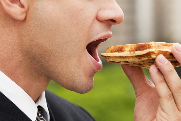 Close-up of a businessman eating a slice of pizza