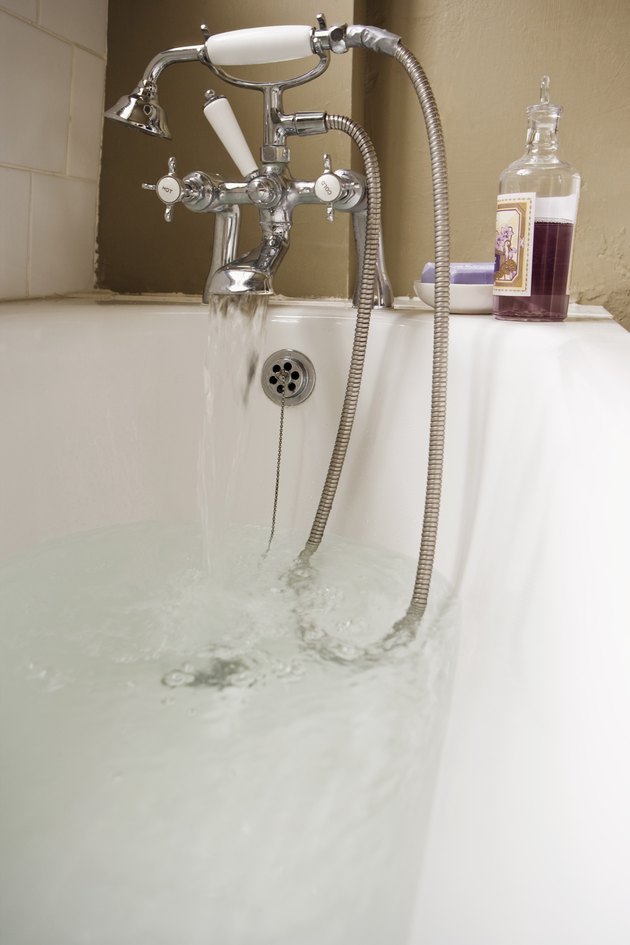 Bath with water flowing from faucet