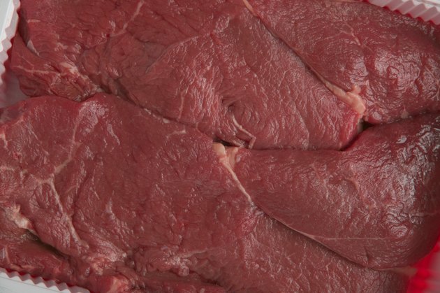 Uncooked sirloin steaks in supermarket package, unwrapped