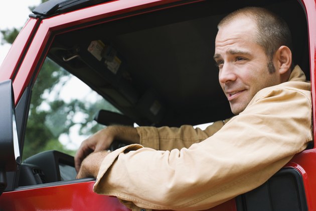 Man driving a jeep and smiling