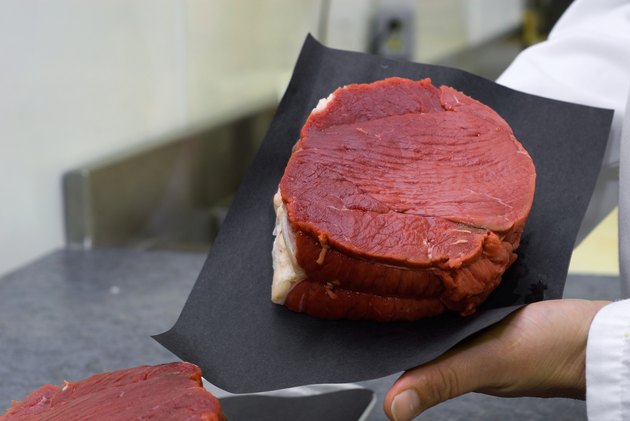 Butcher holding fresh cut of meat