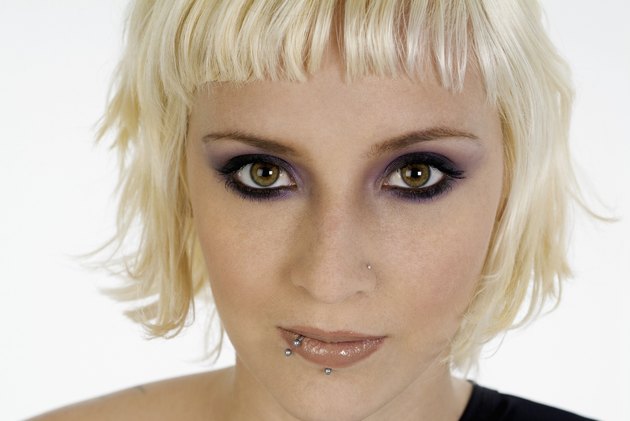 Young woman with bleached blonde hair and face piercings, close-up