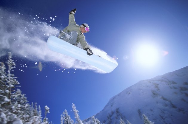 Low Angle Mid Air Shot of a Woman Snowboarding