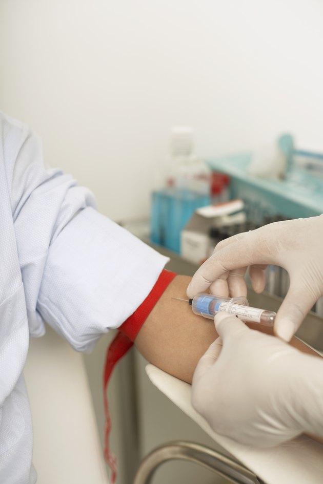 Nurse drawing blood from man's arm
