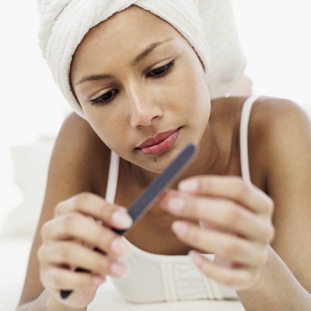 Close-up of a young woman filing finger nails