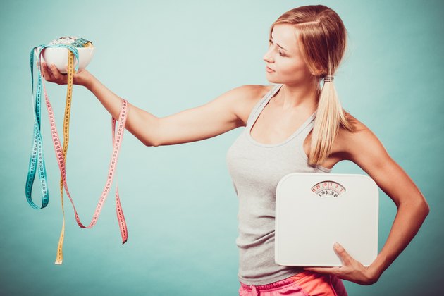 Girl with scales measuring tapes. Weight loss.