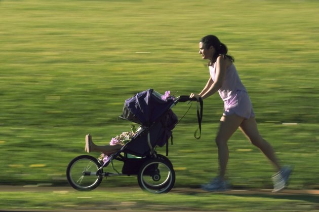 Mother Jogging In The Park With Her Baby In A Stroller