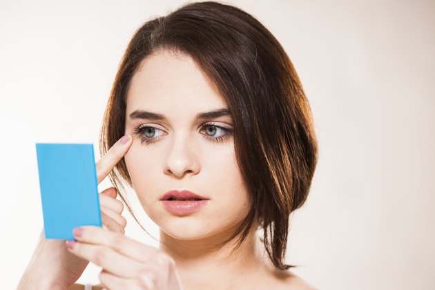 Young woman checking her make up