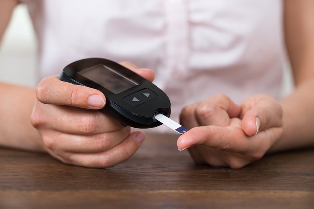 Person Hands Holding Glucometer
