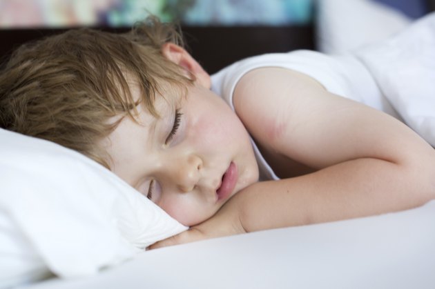 Little sweet toddler boy sleeping in his bed