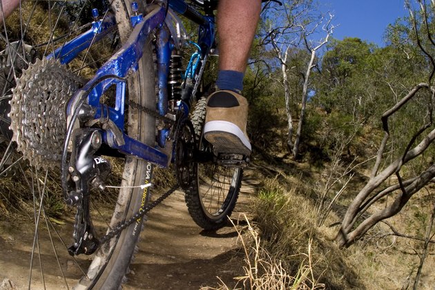A stock photograph of an active young man riging through the country on a mountain bike.