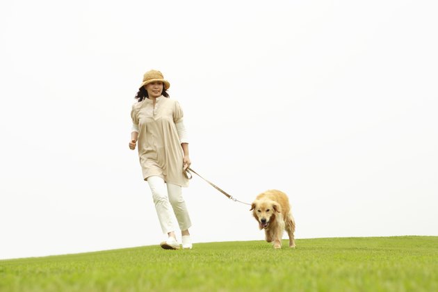 Mature woman running in a park with her dog