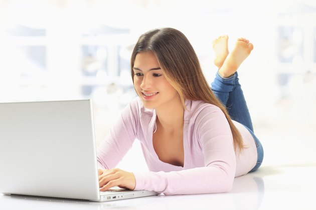 Smiling young woman working on laptop