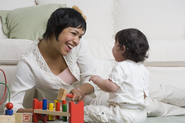 Hispanic mother and baby playing on floor