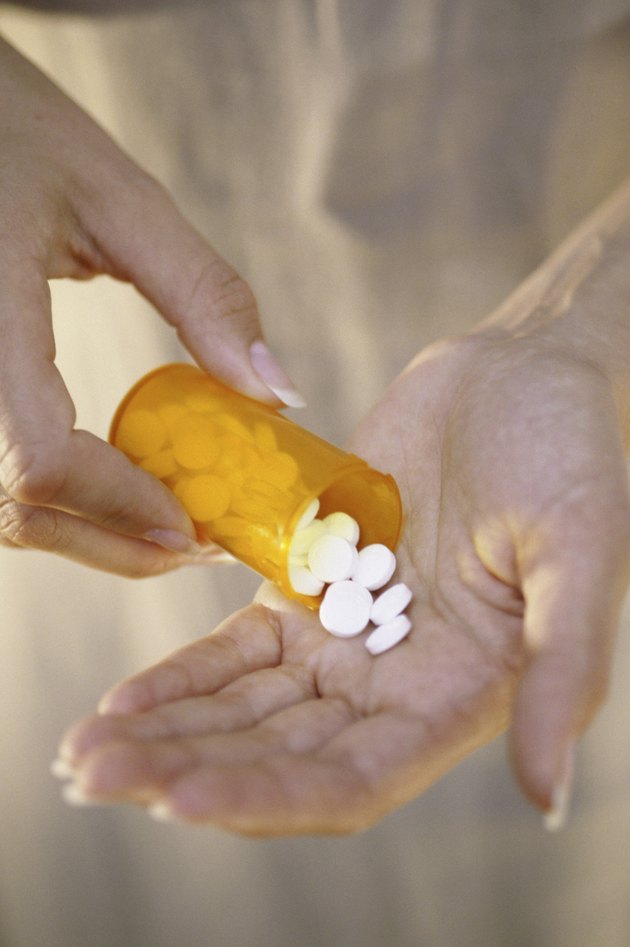 Person holding a vial of tablets