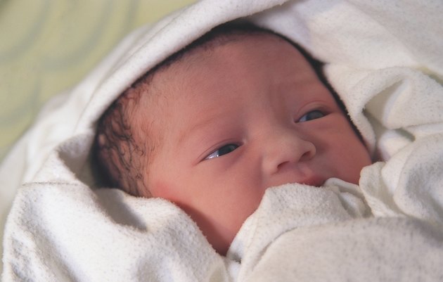 Newborn wrapped in white blanket