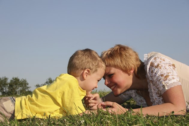 mother with boy lies on meadow
