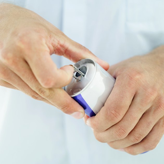 Close-up of a man's hands opening a soft drink can