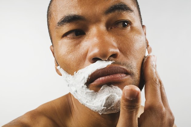 Asian man applying shaving cream