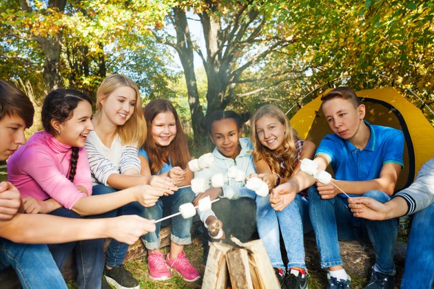 Friends on campsite grill marshmallow together