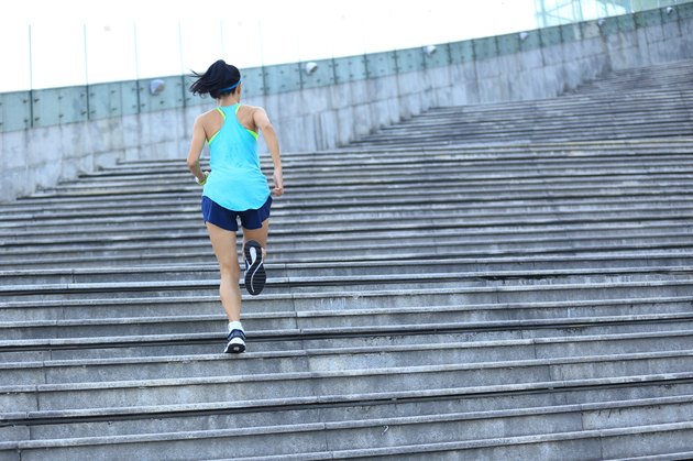 young sports woman running up on stone stairs