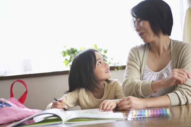 Mother and daughter coloring indoors