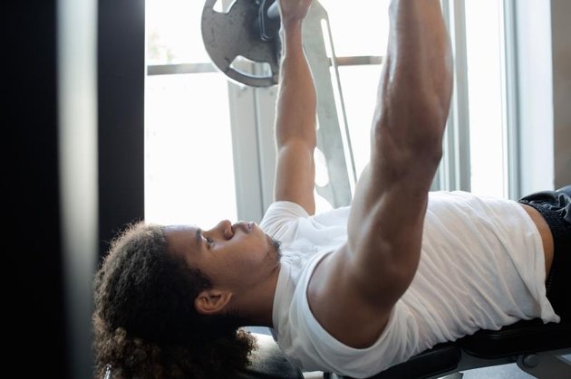 Young hispanic male doing intense physical workout in the gym