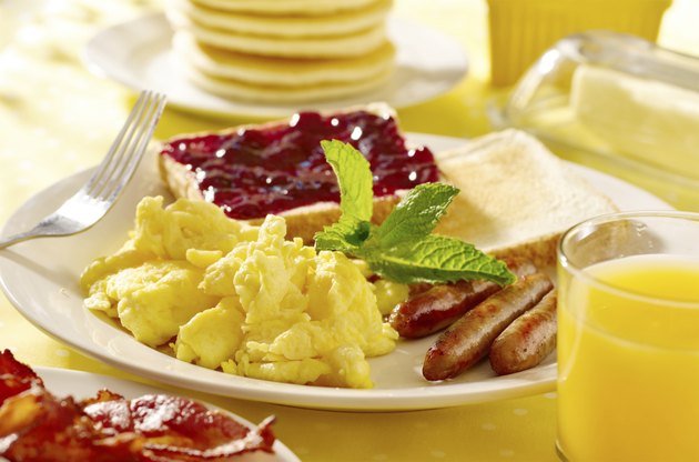 breakfast with scrambled eggs, sausage links and toast.