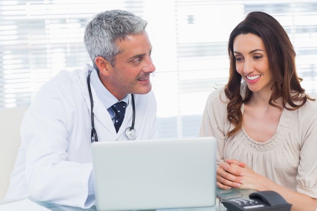 Docter showing something on laptop to his patient
