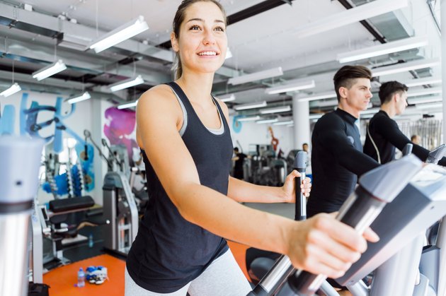 Young fit woman using an elliptic trainer