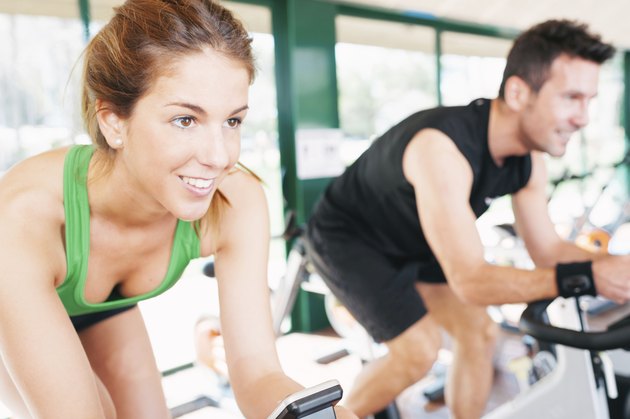 Athletes using the stationary bicycle in a gym