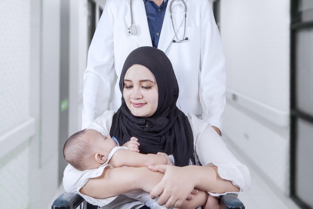 Mother with baby on wheelchair and her doctor