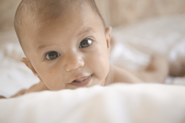 Close-up of a baby lying on a bed