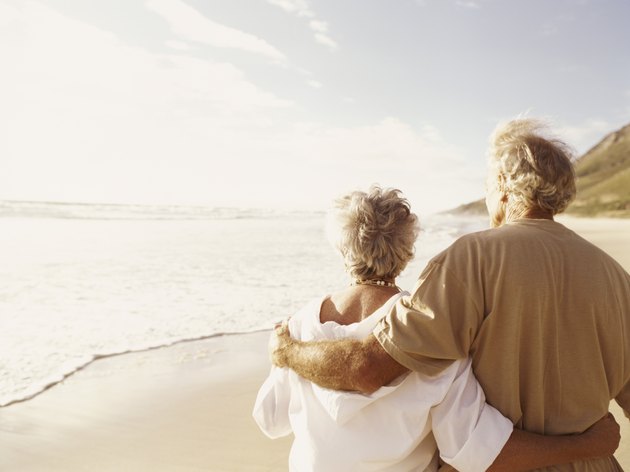 Rear View of a Senior Couple Standing on a Beach With Their Arms Around Each Other