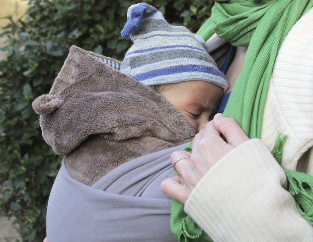 Sleeping baby in a slings - wedding ring on finger