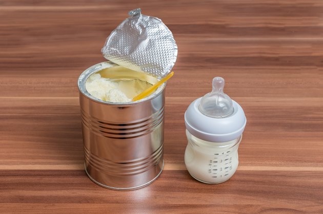 Powdered milk formula in can and bottle for feeding baby