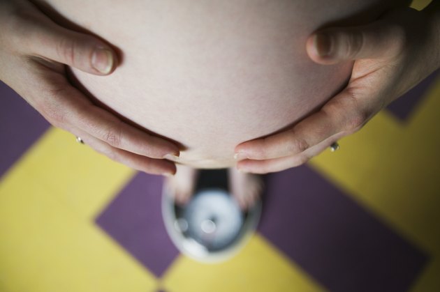 Pregnant woman standing on a scale