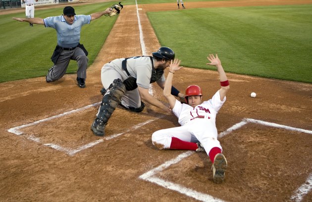 USA, California, San Bernardino, baseball runner sliding safely into home base