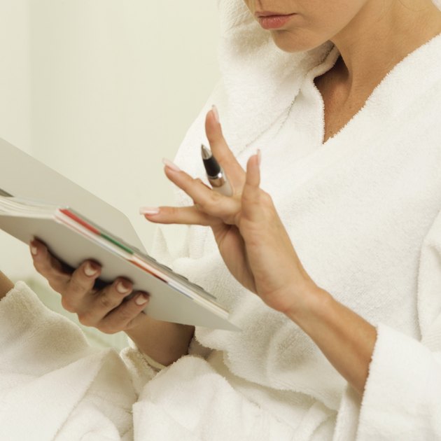 Woman in bathrobe with towel wrapped around her head using appointment book, close-up