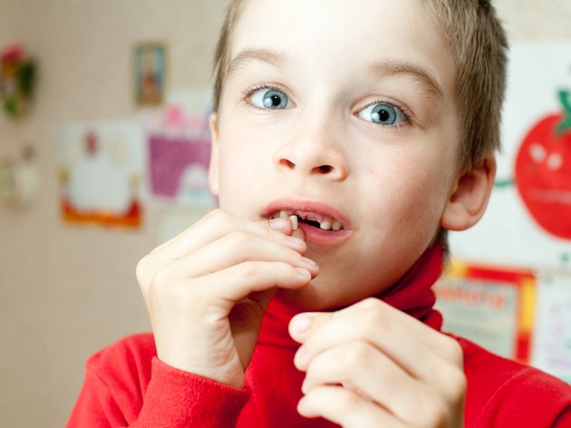 Boy holding missing teeth