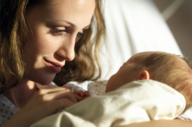 close up as a young attractive mother looks lovingly at her newborn baby daughter
