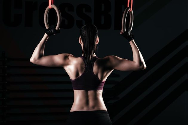 Sporty women in a gym exercising with gymnastic rings
