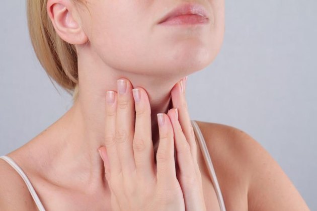 Woman with hands on throat