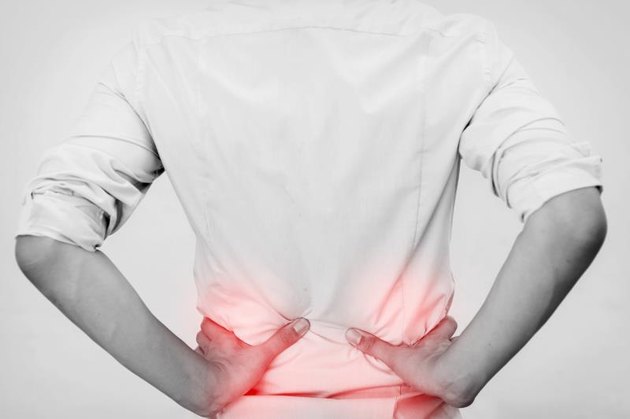 Young man in casual office shirt having hip pain (Focus on hips)