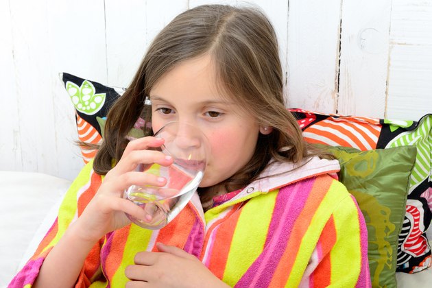 sick girl drinking a glass of water