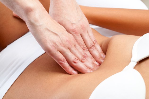 Therapist Hands pressing on female abdomen.