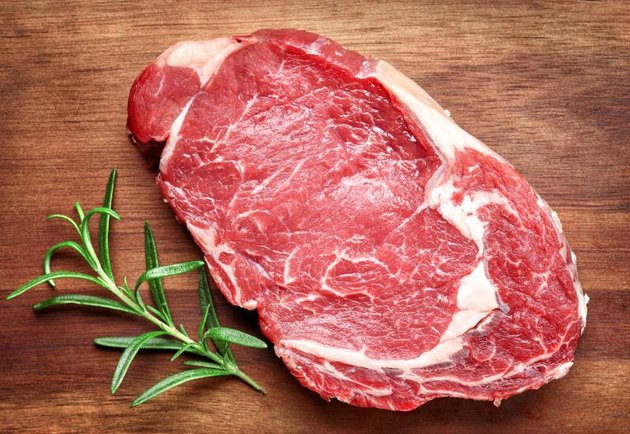 raw beef steak on wooden cutting board