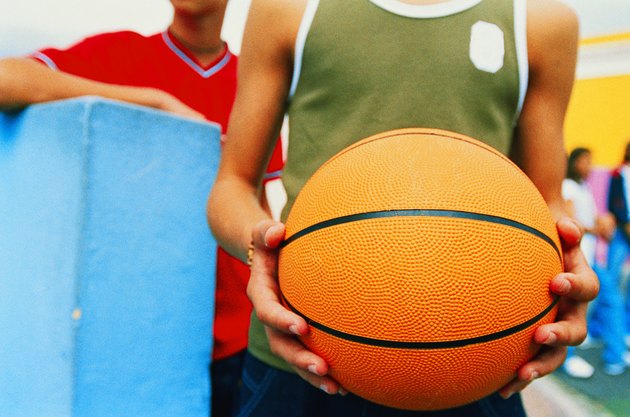 close-up of a teenage boy's hands holding a basketball