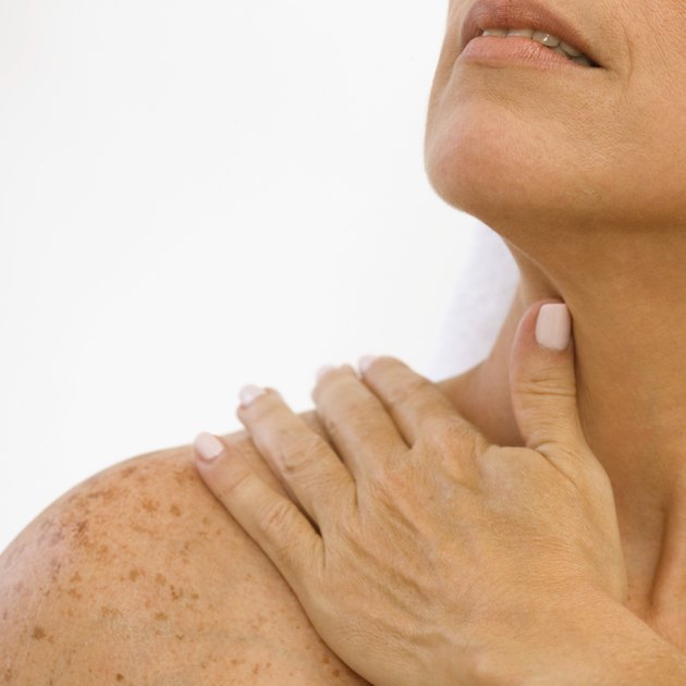 Woman rubbing her shoulder, close-up