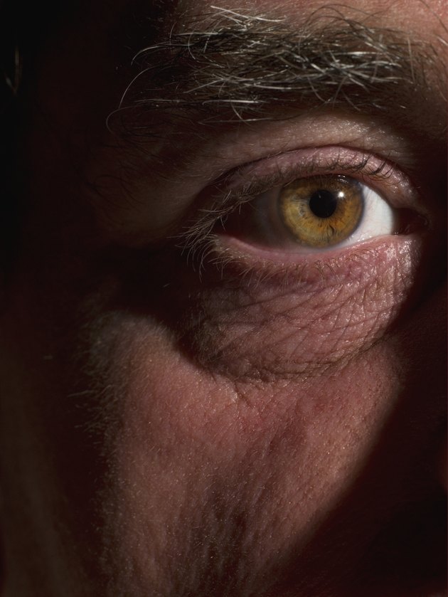 Macro shot of mature man's eye and wrinkles on skin